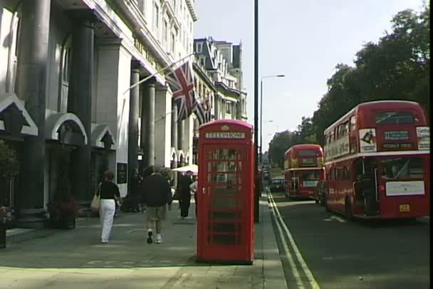 Telefonzelle und Busse auf der Straße in London — Stockvideo