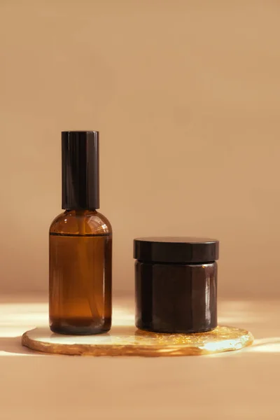 Botol Kosmetik Kaca Coklat Pada Latar Belakang Pastel Cahaya Hangat — Stok Foto