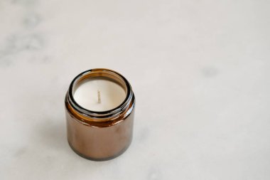 Kahverengi cam ambalajlı organik hindistan cevizi mumu beyaz masada. Ürün fotoğrafçılığı konsepti, minimalizm, fotokopi alanı, durgun yaşam, yukarıdan