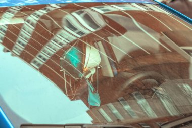 Arabada asılı tıbbi yüz maskeleri, pencereden yansıyan fotoğraflar.