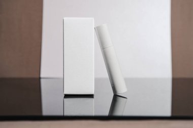 Beyaz kozmetik tüp ve beyaz arka planda kutu. Güzellik reklamı konsepti, blog, geometrik minimalizm ürün fotoğrafçılık, maket, kopyalama alanı