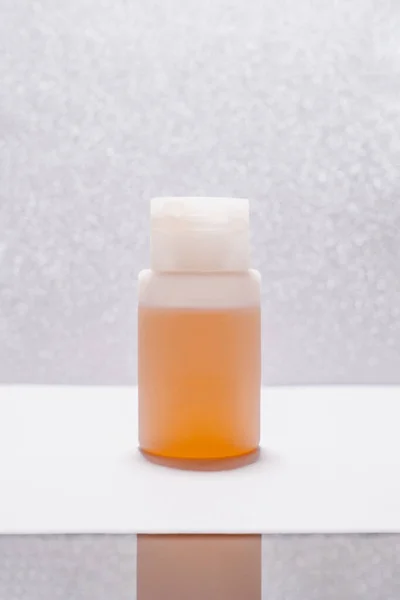 Botol Kosmetik Transparan Dengan Cairan Pada Latar Belakang Perak Yang — Stok Foto