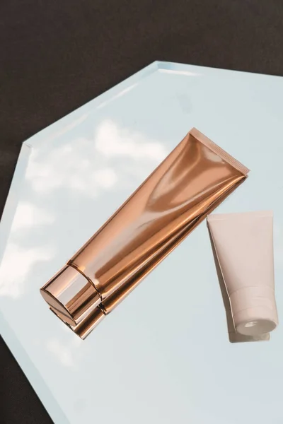 Zwei Weiße Und Goldene Kosmetikröhren Auf Spiegelhintergrund Schönheitsprodukt Branding Paket lizenzfreie Stockbilder