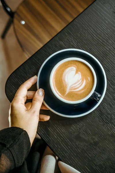 Tangan Wanita Memegang Kopi Cappuccino Atas Meja Kayu Hitam Kedai — Stok Foto