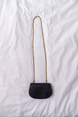 Beyaz arka planda kadının siyah mini çantası. Şık aksesuar, moda blogu, minimalist tarz, kopyalama alanı, kapanış, reklam modeli