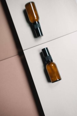 Düz cilt bakımı bej renkli nötr kağıtta hala hayat dolu. Kahverengi cam şişe, ticari stüdyo çekimi, reklam, sürdürülebilir, minimalizm konsepti, geometrik çizgiler, kapatın, modelleyin