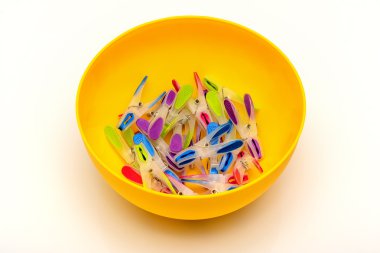 Sarı bir kase çok renkli clothespins dönüştürün.