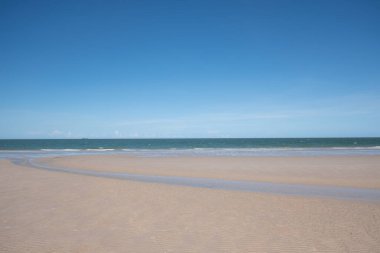 Beyaz kumlu güzel sahil, turkuaz okyanus suyu ve güneşli bir günde bulutlu mavi gökyüzü. Huahin, Tayland 'da