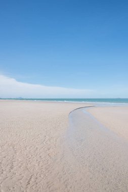 Beyaz kumlu güzel sahil, turkuaz okyanus suyu ve güneşli bir günde bulutlu mavi gökyüzü. Huahin, Tayland 'da