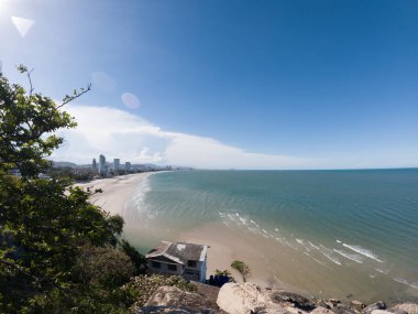 Beyaz kumlu güzel sahil, turkuaz okyanus suyu ve güneşli bir günde bulutlu mavi gökyüzü. Huahin, Tayland 'da