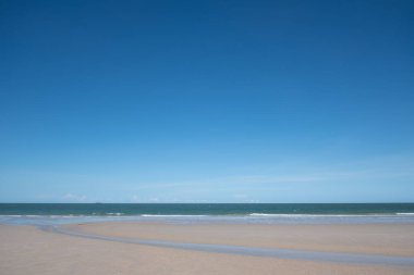 Beyaz kumlu güzel sahil, turkuaz okyanus suyu ve güneşli bir günde bulutlu mavi gökyüzü. Huahin, Tayland 'da