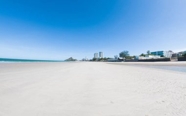 Beyaz kumlu güzel sahil, turkuaz okyanus suyu ve güneşli bir günde bulutlu mavi gökyüzü. Huahin, Tayland 'da