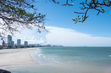 Beyaz kumlu güzel sahil, turkuaz okyanus suyu ve güneşli bir günde bulutlu mavi gökyüzü. Huahin, Tayland 'da