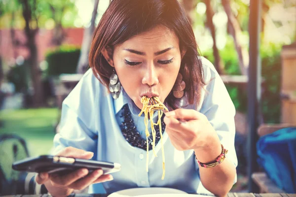 Las mujeres asiáticas son felices cuando comen y juegan móvil —  Fotos de Stock