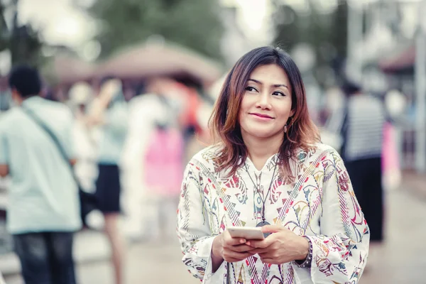 携帯電話を見ているアジアの女性の写真 — ストック写真