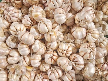 Taze sarımsak soğanlarıyla dolu bir çerçeve. Yerel pazarda yüksek açılı organik sarımsak yığını.