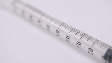 Temiz beyaz bir zemin üzerinde tıbbi bir şırınga makro çekim, sağlık, aşı ve ilaç stok görüntüleri için ideal