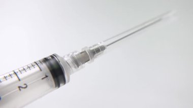 İzole edilmiş bir arka planda, sağlık gösterileri, aşı içeriği ve tıbbi stok görüntüleri için uygun bir şırınga kapağının makro yakın çekimi kaldırılıyor..