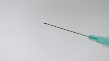 İğne ucu damlayan şırınganın yakın çekimi. Tıbbi görüntüler.