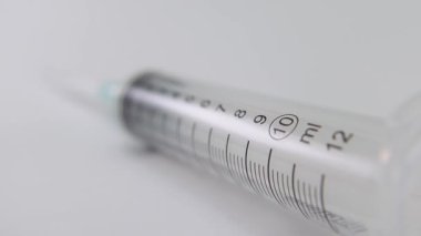 Beyaz bir yüzeye yerleştirilmiş steril şırınganın yüksek ayrıntıları, sağlık hizmetleri için uygun.