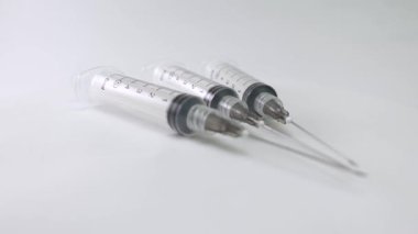 Steril şırıngalar ve iğneler düzgün bir şekilde döner döner döner platforma yerleştirilmiş, sağlık, aşı ve ilaç stoku görüntüleri için ideal..