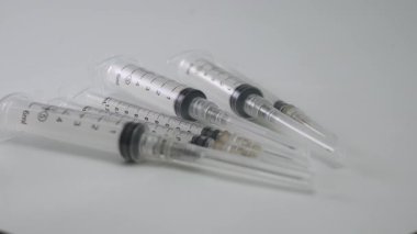 Keskin iğneli steril tıbbi şırıngalar döner döner platformda dairesel bir düzende düzenlenir. Sağlık, aşı, aşı ve ilaç temalı stok görüntüleri için mükemmeldir..