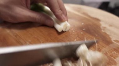 Şef, kökleri kestikten sonra keskin bir bıçakla taze soğan dilimliyor. Mutfakta pişirmek için taze malzemeler hazırlıyor.