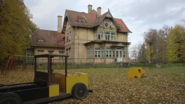 Régi kísértetjárta ház oldschool játszótérrel, őszi — Stock videók
