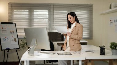 Business asian woman reading document paper on working table at office.