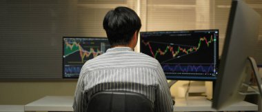 Busy business man trader broker analyst investor analyzing stock exchange trade crypto market using pc computer digital data investing finances in stock market working in dark office..