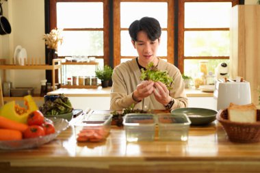 Sağlıklı ev yapımı yemekleri evde taze yiyeceklerle hazırlayan bir adam...