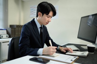 Modern ofiste maliyet, hesap makinesi ve bilgisayar konularında finansman ile çalışan işadamı..