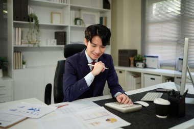 Modern ofiste maliyet, hesap makinesi ve bilgisayar konularında finansman ile çalışan işadamı..