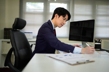 Modern ofiste maliyet, hesap makinesi ve bilgisayar konularında finansman ile çalışan işadamı..