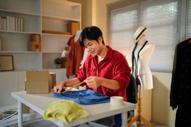 Bir adam bir kumaş parçası üzerinde çalışıyor. Ölçülerini alıyor ve doğru olmak için elinden geleni yapıyor.,.