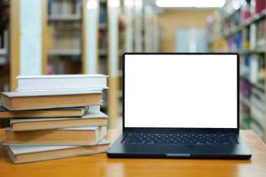 Kütüphane öğrenme ve eğitim konsepti kitaplarıyla çevrili dizüstü bilgisayar görüntüsü.
