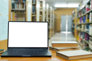 Dizaynınız için bulanık kütüphane arka planı, kitaplar ve dizüstü bilgisayarlı masa.