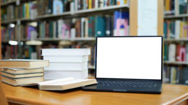 Dizaynınız için bulanık kütüphane arka planı, kitaplar ve dizüstü bilgisayarlı masa.