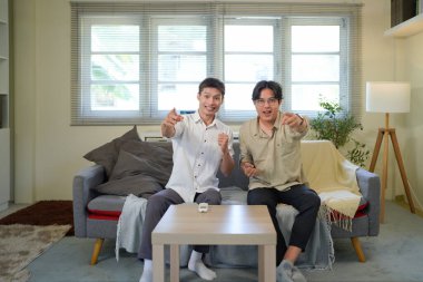 İki arkadaş evdeki oturma odasında maç izlerken tezahürat yapıyor..