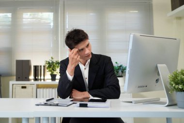 Ciddi, iş adamı ve ofisteki bilgisayar, internet araştırmaları ve web sitesi üzerinde düşünme. Odaklanmış erkek çalışan, fikirlerin masaüstü ve çözümü, planlama ve değerlendirme stratejisi, proje veya vizyon.