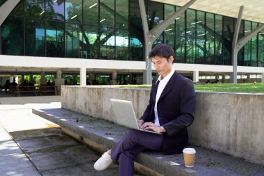 Girişimci açık havada melez bir şekilde çalışıyor. Mutlu iş adamı girişimci ofis dışında dizüstü bilgisayar kullanarak başka tarafa bakıyor. Boşluğu kopyala..