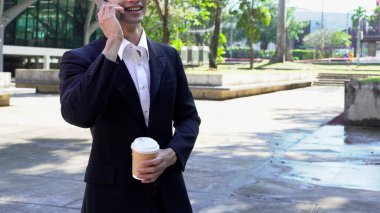 Genç iş adamı kahve molasında dışarıdaki ofis binasından arıyor. Sokaklarda yürüyen bir iş adamı...
