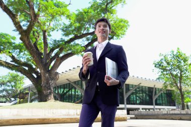 Bilgisayarlı bir iş adamı ve dışarıda kahve içiyor. Takım elbiseli bir iş adamı ofis işlerine gider. Başarı işi..