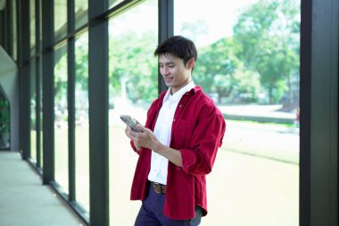 Ofis arka planında akıllı telefon kullanan işadamı ve kopyalama alanı.