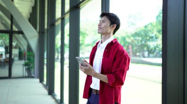 Ofis arka planında akıllı telefon kullanan işadamı ve kopyalama alanı.