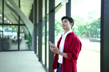 Ofis arka planında akıllı telefon kullanan işadamı ve kopyalama alanı.