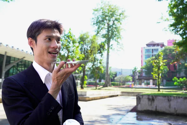 Genç iş adamı kahve molasında dışarıdaki ofis binasından arıyor. Sokaklarda yürüyen bir iş adamı...