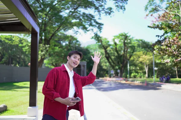 Akıllı telefonu olan Asyalı bir adam arkadaşlarıyla buluşur ya da akşam sokakta taksi çağırır..