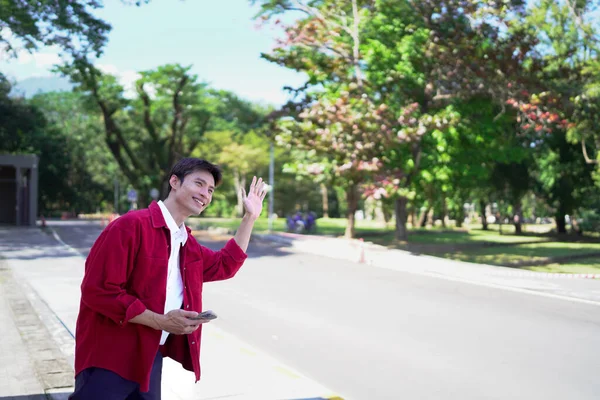 Akıllı telefonu olan Asyalı bir adam arkadaşlarıyla buluşur ya da akşam sokakta taksi çağırır..