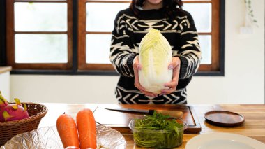 Evde mutfakta lahana tutan bir kadın..